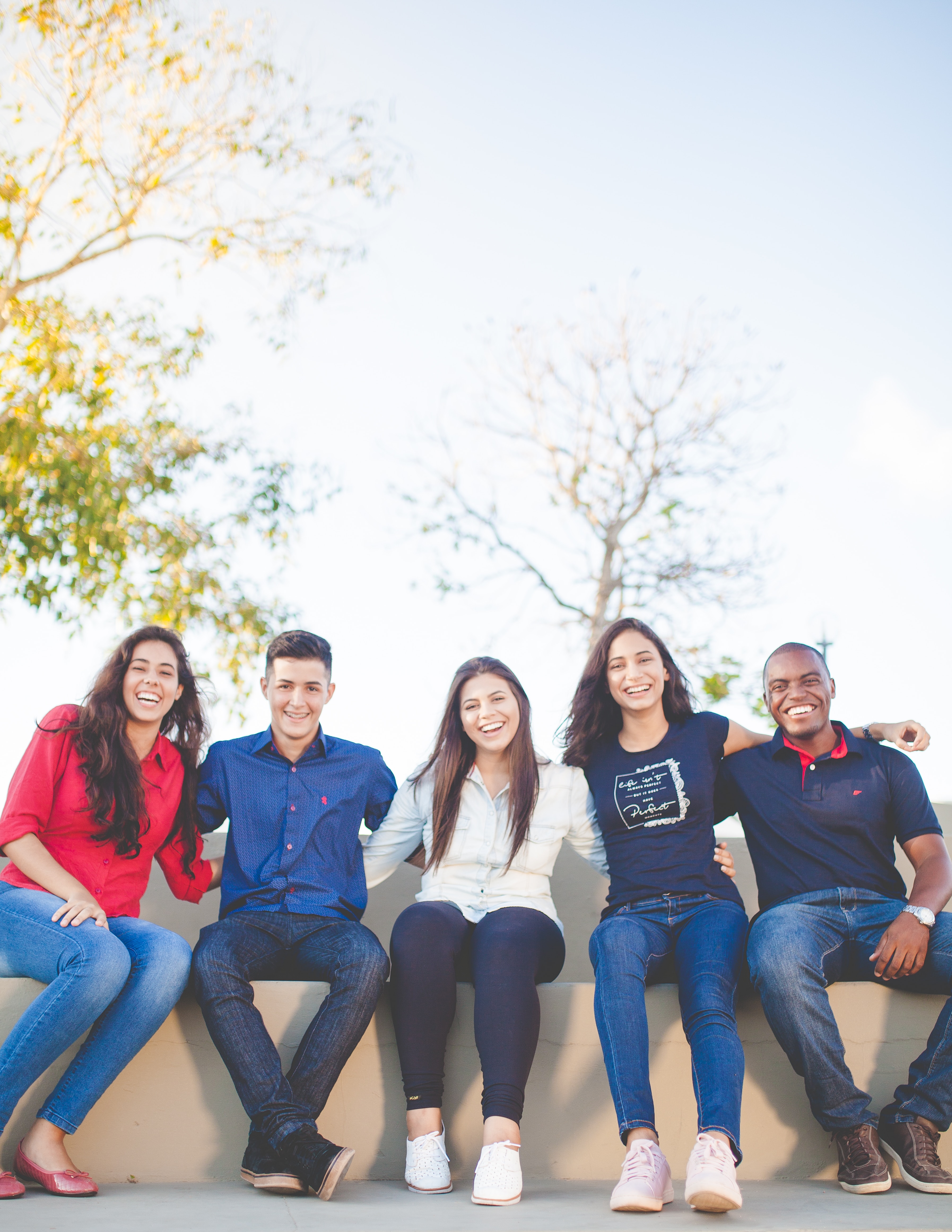 Group of teenagers sat on wall together